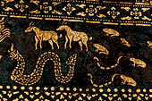 Wat Xieng Thong temple in Luang Prabang, Laos. Detail of the  intricate gold stencilling on black lacquer that decorate the walls of the sim. 